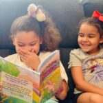 two girls laughing while reading Where do Unicorns go on vacation