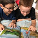two boys reading a picture book